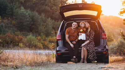 Familie mit kleiner Tocher im Kofferraum sitzend