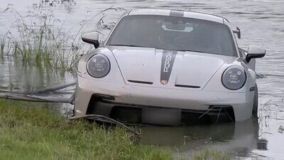 Der Porsche landete im Flussbett, nach wenigen Minuten war er mit Wasser vollgelaufen. Bild: Screenshot BRK News, Youtube