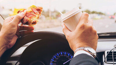 Die Pizza am Steuer zu essen, ist keine gute Idee. Wer erwischt wird, muss mit einer Verzeigung rechnen. Bild: freepik.