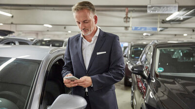 Ein Mann bucht einen Parkplatz auf seinem Smartphone