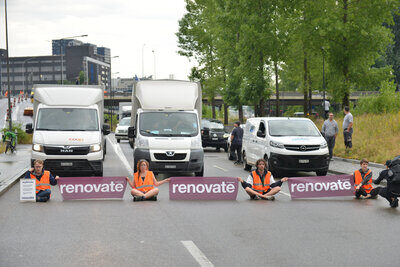 Klimakleber vor blockierten Autos am Boden sitzend