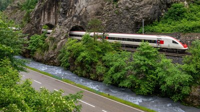 Ein Intercity fährt entlang eines Fluss durch die Natur