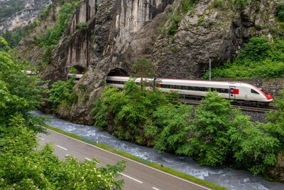 Ein Intercity fährt entlang eines Fluss durch die Natur