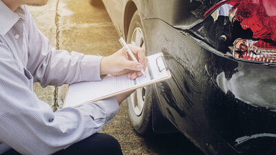 Verischerungsagent untersucht Unfall