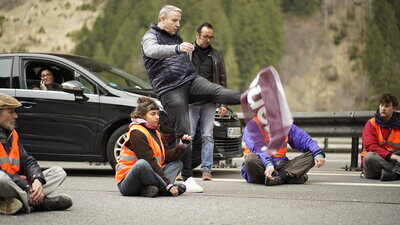 Unbeteiligter Kick in Demonstrationsplakat von Klimaklebern