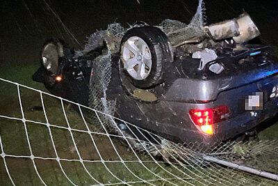 Nach der Kollision mit dem Wildschutzzaun blieb der BMW auf dem Dach in der Wiese liegen. Bild: Kantonspolizei Solothurn