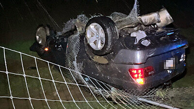 Nach der Kollision mit dem Wildschutzzaun blieb der BMW auf dem Dach in der Wiese liegen. Bild: Kantonspolizei Solothurn
