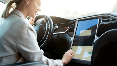 Frau bedient Touchscreen im Auto
