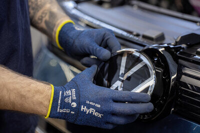 Hand setzt VW-Logo bei einem Auto ein